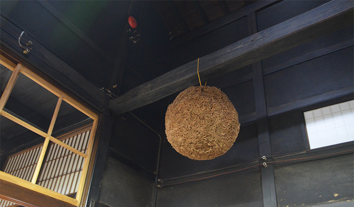 A seasoned cedar ball is being suspended from the ceiling.